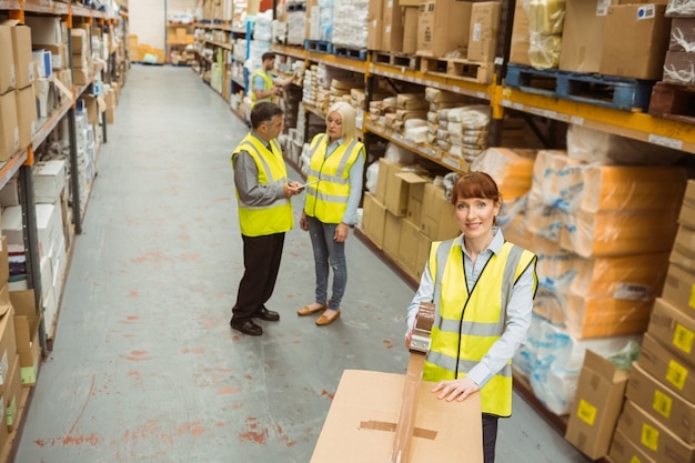 Warehouse worker sealing cardboard boxes for shipping