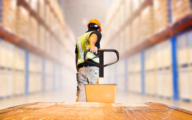 Photo warehouse worker using hand pallet jack unloading package boxes cargo supply chain shipping boxes