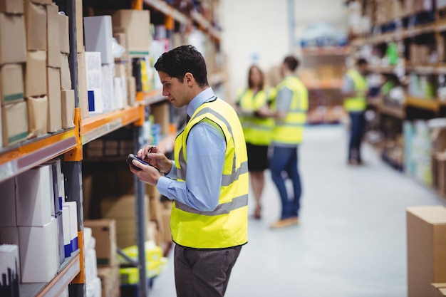 Warehouse worker using hand scanner in warehouse