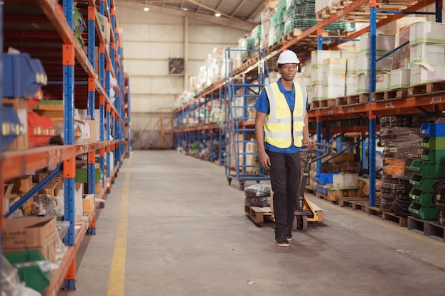 Warehouse workers pushing a pallet truck in a shipping and distribution warehouse