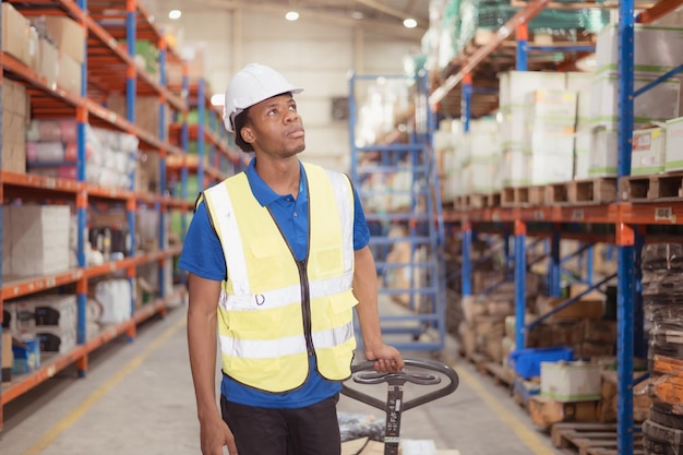 Warehouse workers pushing a pallet truck in a shipping and distribution warehouse