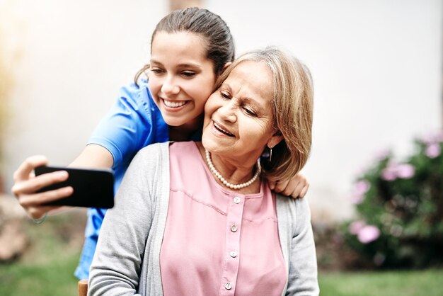 Waren zo close als familie Bijgesneden opname van een verzorger die een selfie maakt met een oudere patiënt buiten