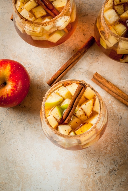 Warm apple cider with pieces of fruit and cinnamon