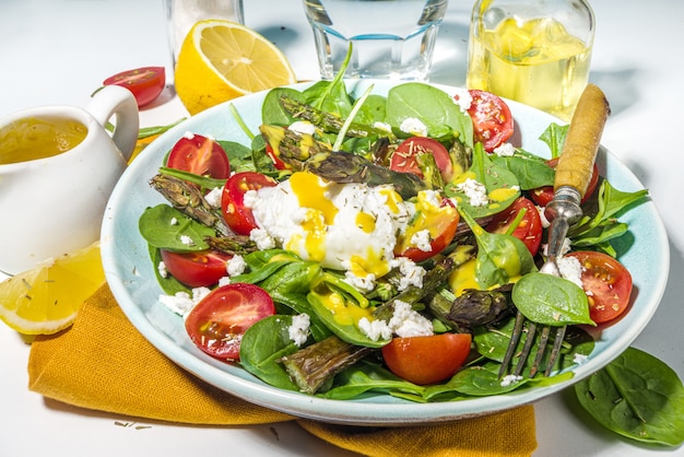  warm asparagus salad with baby spinach, cherry tomatoes, feta cheese and poached egg