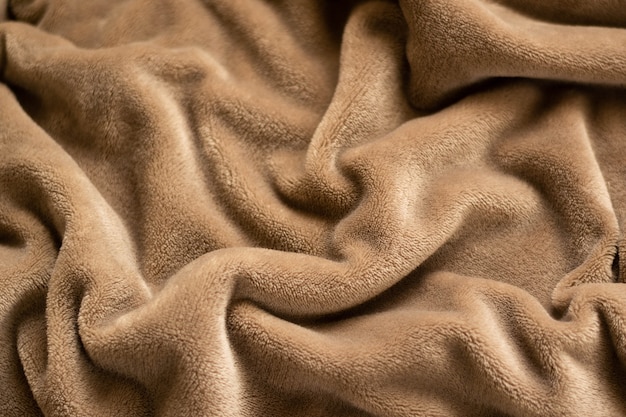 Una calda coperta in tessuto micropile di peluche, roteata in uno sfondo fantasia