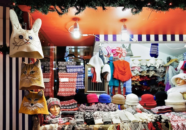 Photo warm colorful hats, mittens, gloves and socks at one of the stalls at the street christmas market in riga, latvia. the market is full of warm clothes and souvenirs.