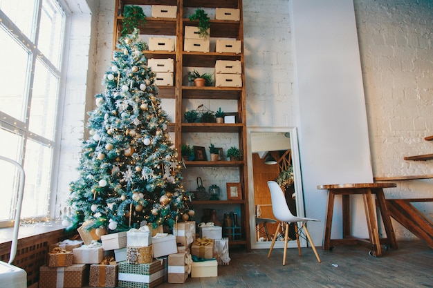 크리스마스 트리로 장식된 섬세하고 밝은 색상의 방의 따뜻하고 아늑하고 아름다운 현대적인 디자인...
