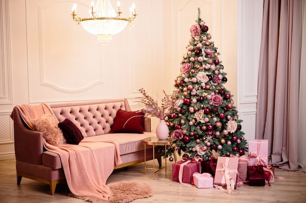 Теплый уютный красивый современный номер с дизайном в нежных светлых тонах украшен елкой и элементами декора к новому году.