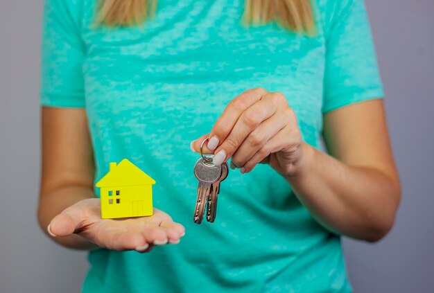 Foto casa in miniatura calda e accogliente in mani femminili cura e amore