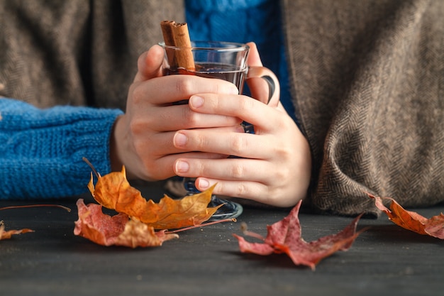 Warm cup of hot mulled wine warming in the hands of a girl