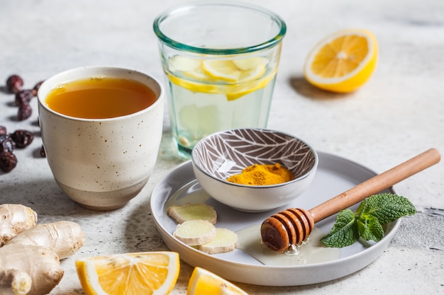 Photo warm drinks with turmeric, ginger, honey, mint and lemon. beverage for boosting immunity concept.