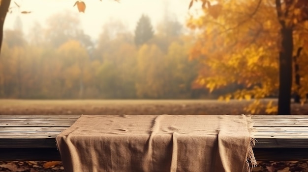 Warm empty wooden table with tablecloth over autumn nature