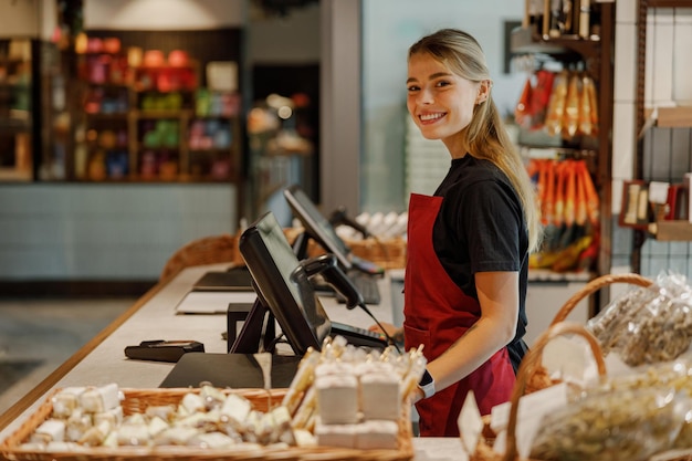 Теплый и дружелюбный кассир, усердно работающий в оживленном продуктовом магазине