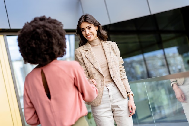 Warm Handshake and Laughter at a Professional Networking Event in a Modern Glass Building