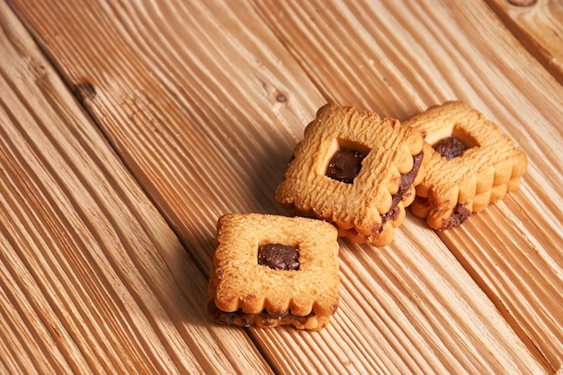 Foto biscotti gingersnap casalinghi caldi condita con cioccolato sulla tavola di legno