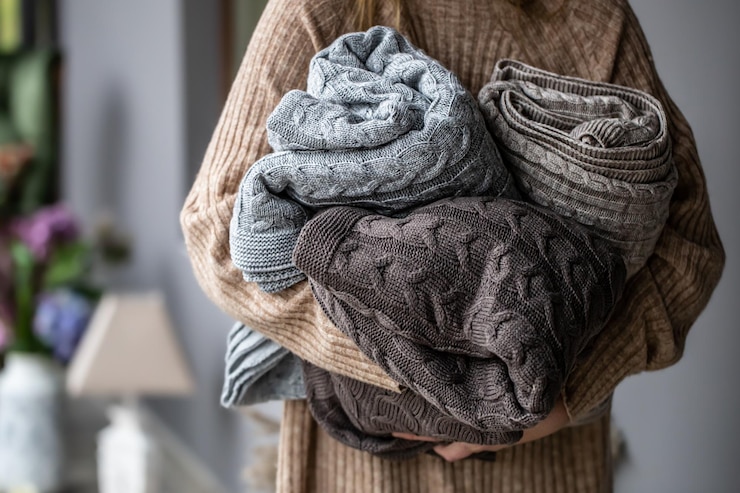 Photo warm knitted blankets in pastel colors in womens hands