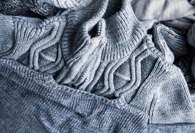 Warm knitted textile stack with the different texture in grey color palette close up