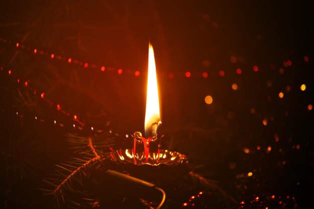 Warm light of burning colorful candle flame on christmas tree background