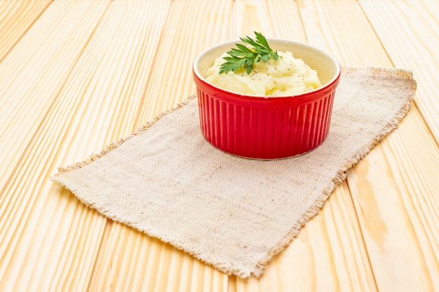 Warm mashed potatoes in a ceramic bowl with fresh parsley