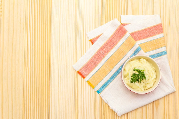 Warm mashed potatoes in a ceramic bowl with fresh parsley