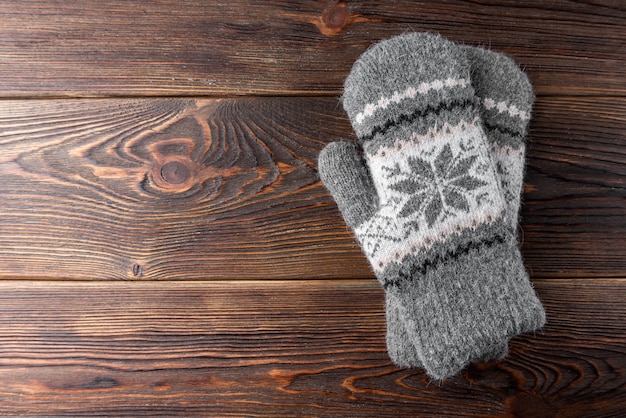 Photo warm mittens on wooden background.