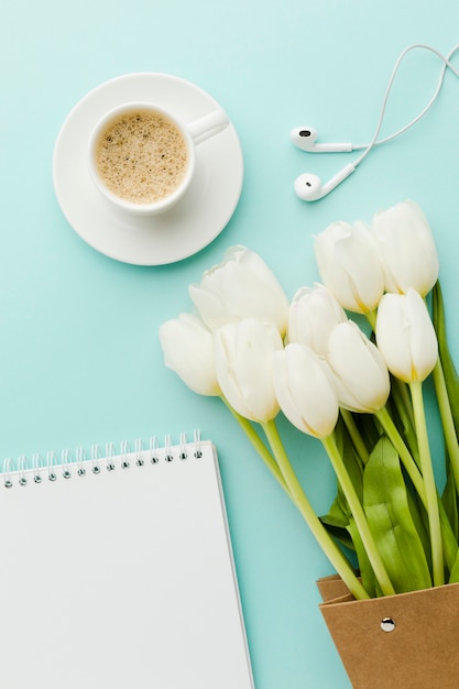 Foto caffè caldo del mattino con fiori e cuffie di tulipani