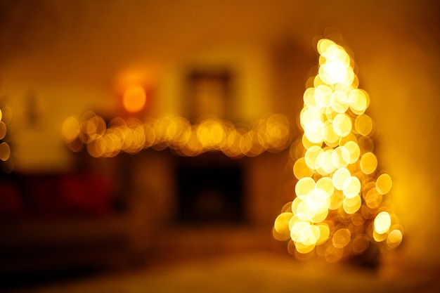Warm new year home interior with christmas tree and festive lighting blurred holiday background
