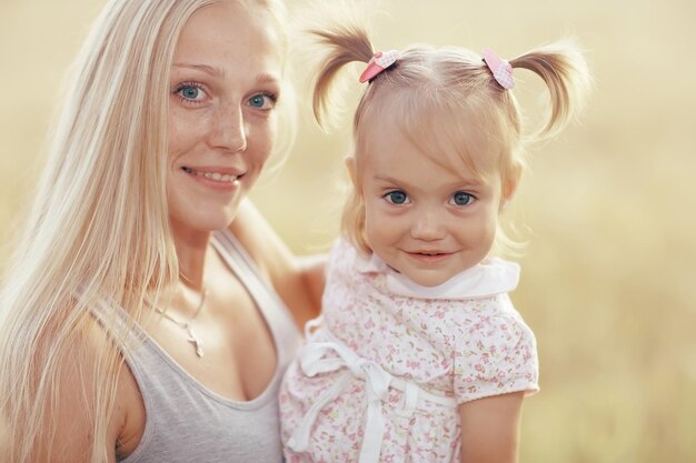 warm portrait of mother and daughter in country style in the field