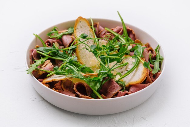 Warm salad of veal and arugula with almonds