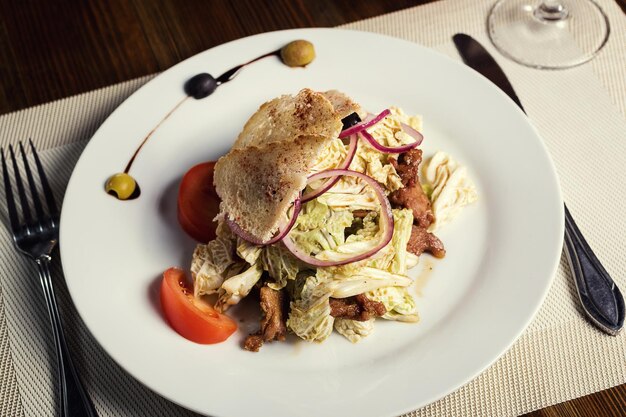 Warm salad with veal pepper cabbage tomatoes and onions in a restaurant