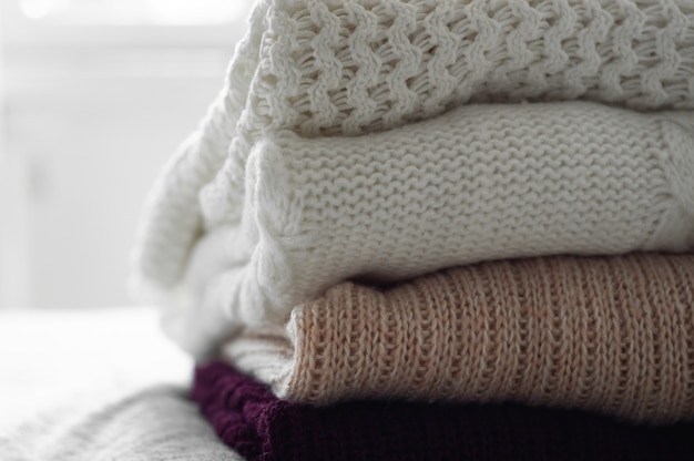 Warm sweaters. Pile of knitted clothes, sweaters, knitwear, Autumn winter concept.