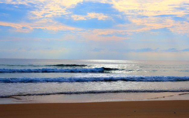 熱帯のビーチの暖かい波が砂を洗い流す