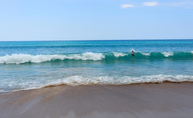 熱帯のビーチの暖かい波が砂を洗い流す