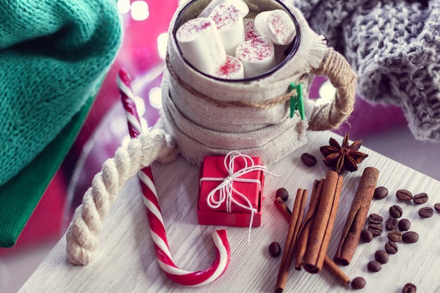 Warm winter mug with marshmallow, striped lollipop and gift