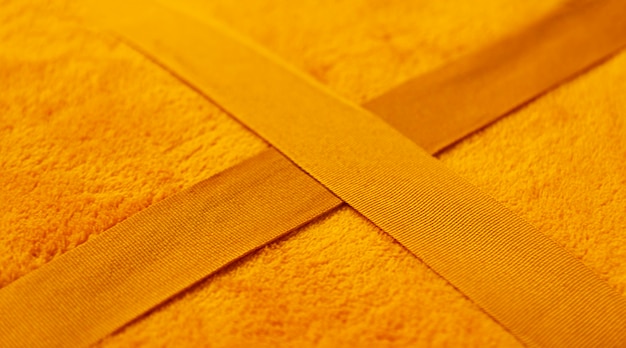 Foto warm zacht geel geruit oppervlak close-up. synthetische doek textuur.