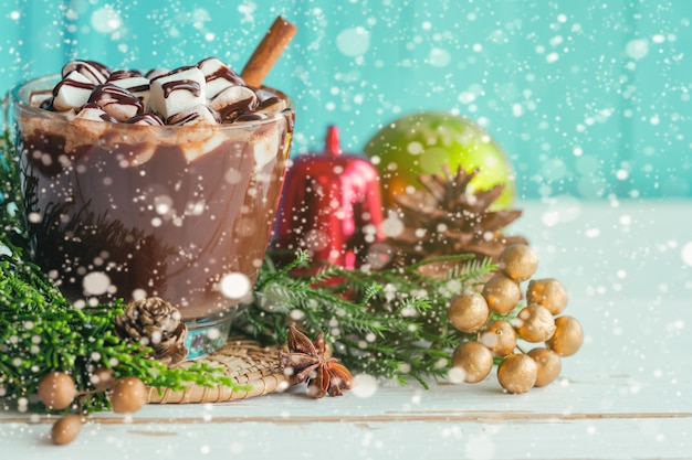 Warme chocola in glazen topping met marshmallow en chocoladesaus in kerstthema.
