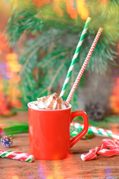 Warme chocolademelk beker met slagroom op houten tafel en papieren rietjes