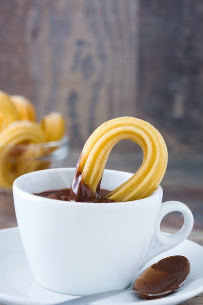 Warme chocolademelk met churros op houten tafel Spaans ontbijt