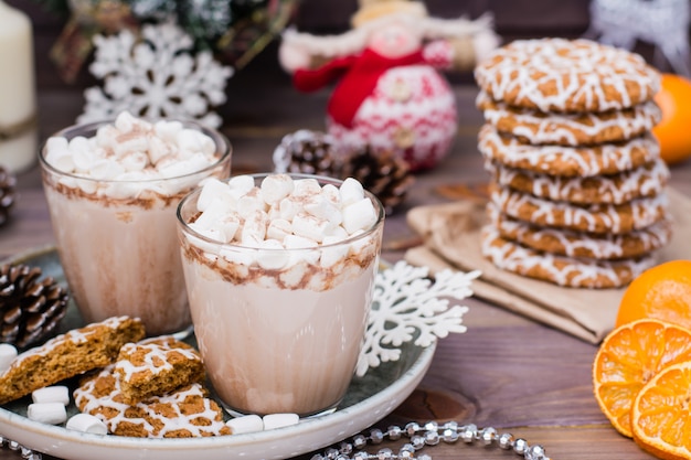 Warme chocolademelk met marshmallows en kaneel in glazen op tafel met kerstversiering
