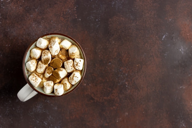 Warme chocolademelk met marshmallows in een witte mok op een roestige achtergrond. Winter. Recepten.