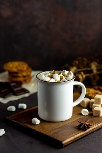 Warme chocolademelk met marshmallows in een witte mok op een roestige