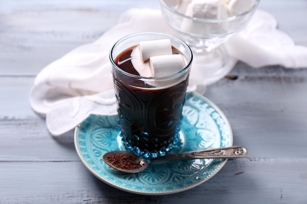 Warme chocolademelk met marshmallows in glas, op een houten achtergrond kleur