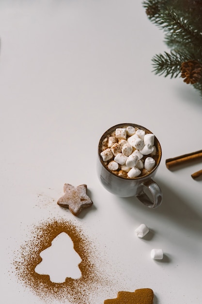 Warme chocolademelk met marshmallows in kerstsfeer met peperkoek.