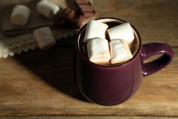 Warme chocolademelk met marshmallows in mok, op houten achtergrond
