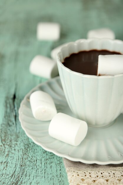 Warme chocolademelk met marshmallows in mok, op houten achtergrond