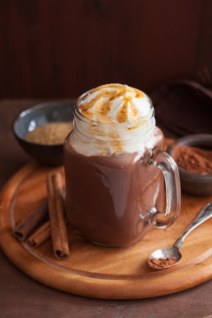 Warme chocolademelk met slagroom karamel in glazen pot