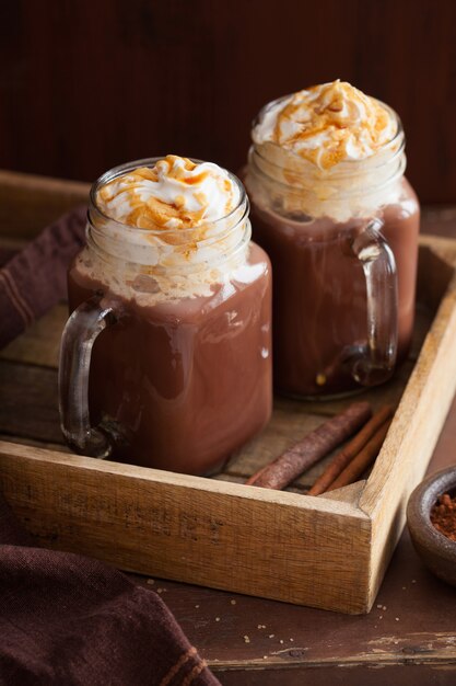 Warme chocolademelk met slagroom karamel in glazen pot