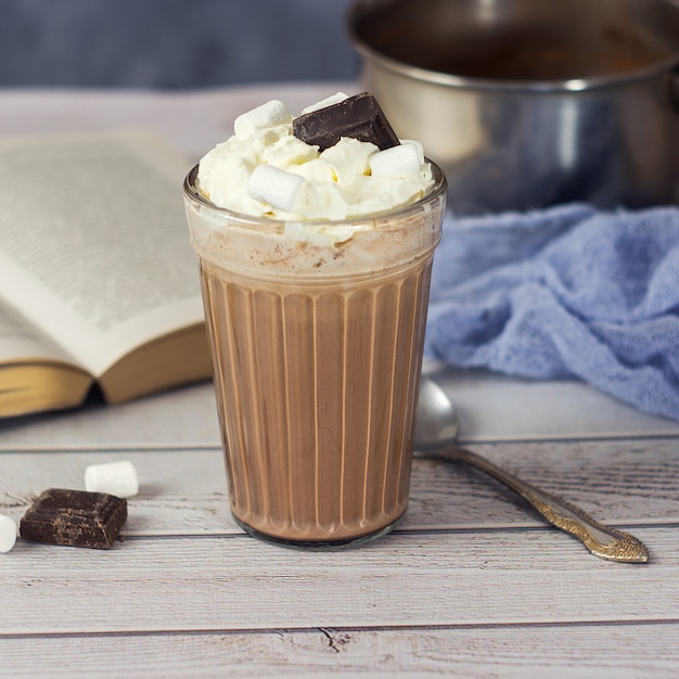 Warme chocolademelk of cacao in glas met slagroom en stukjes chocolade