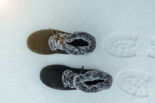 Warme damesschoenen met sporen in de sneeuw. Mooie en praktische dames winterschoenen.