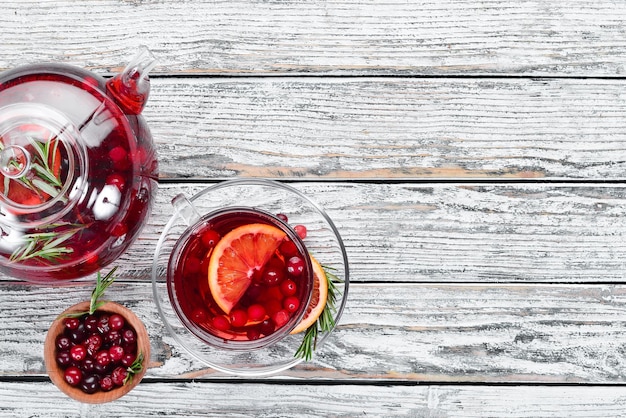 Warme drank van cranberry en sinaasappel in kopjes Op een witte houten achtergrond Bovenaanzicht Vrije ruimte voor uw tekst